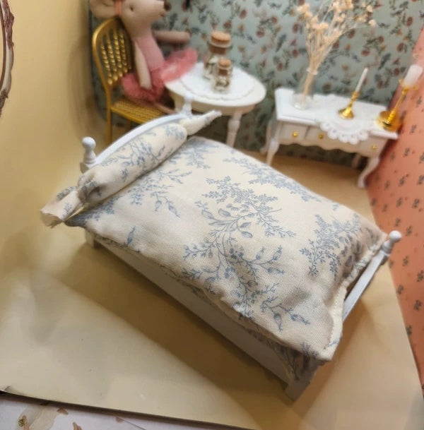 Lit simple blanc en bois avec sa literie couette et traversin