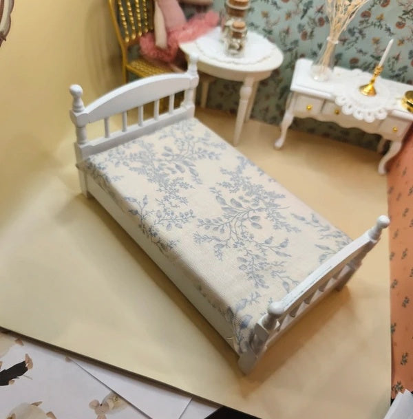 Lit simple blanc en bois avec sa literie couette et traversin