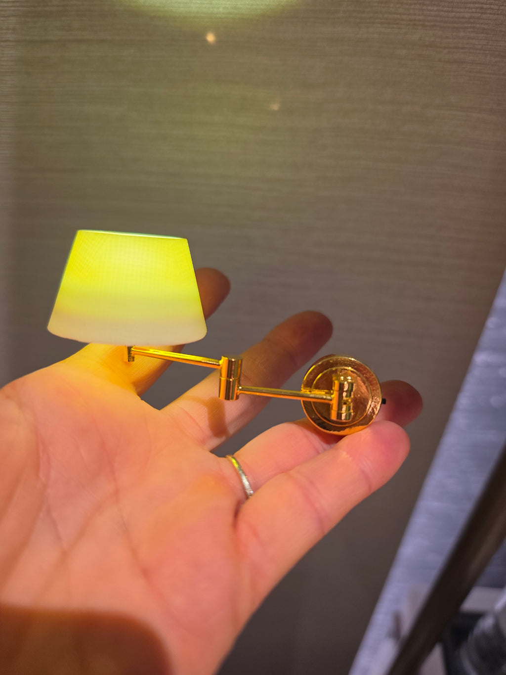 Applique à bras articulé en situation dans une chambre miniature
