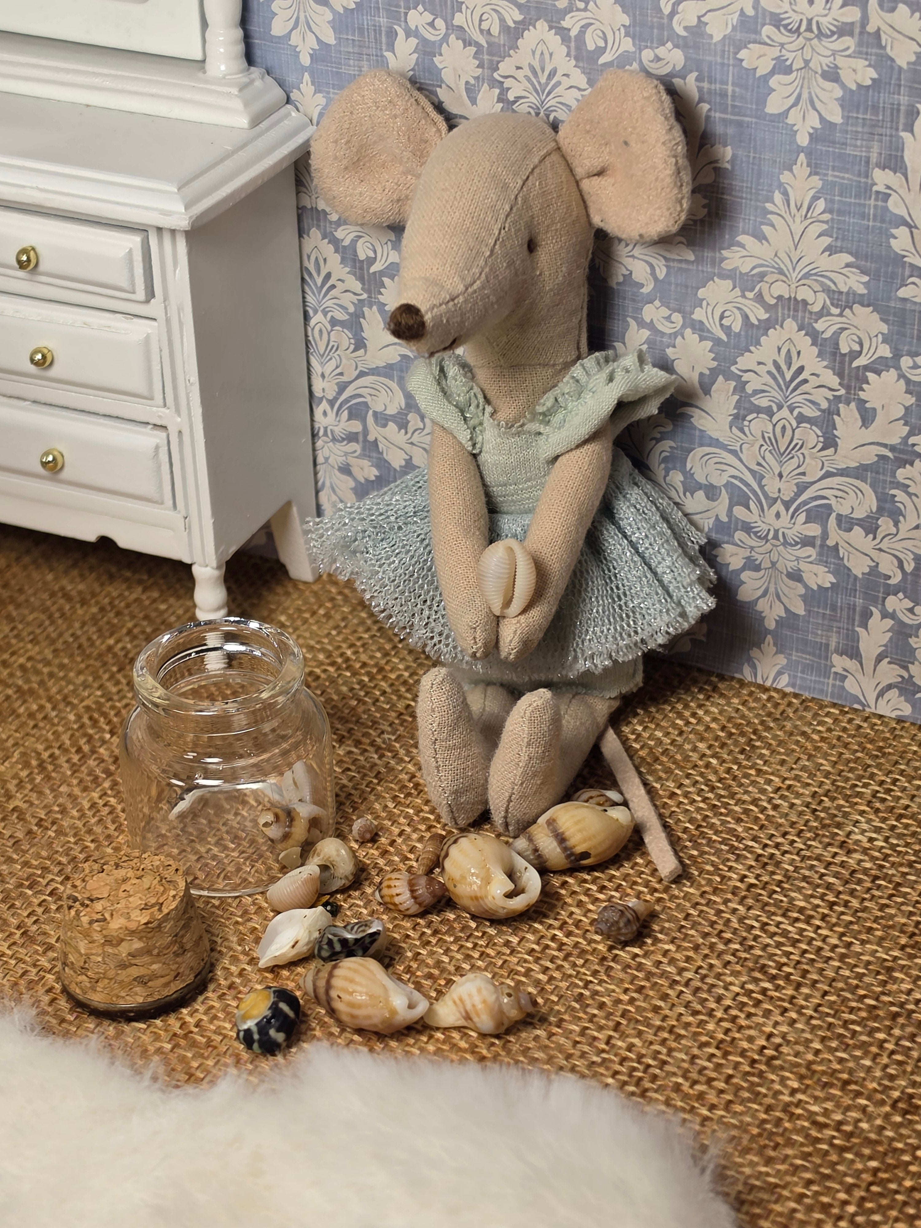 Bocal miniature de coquillages en situation dans une salle de bain de maison de poupée