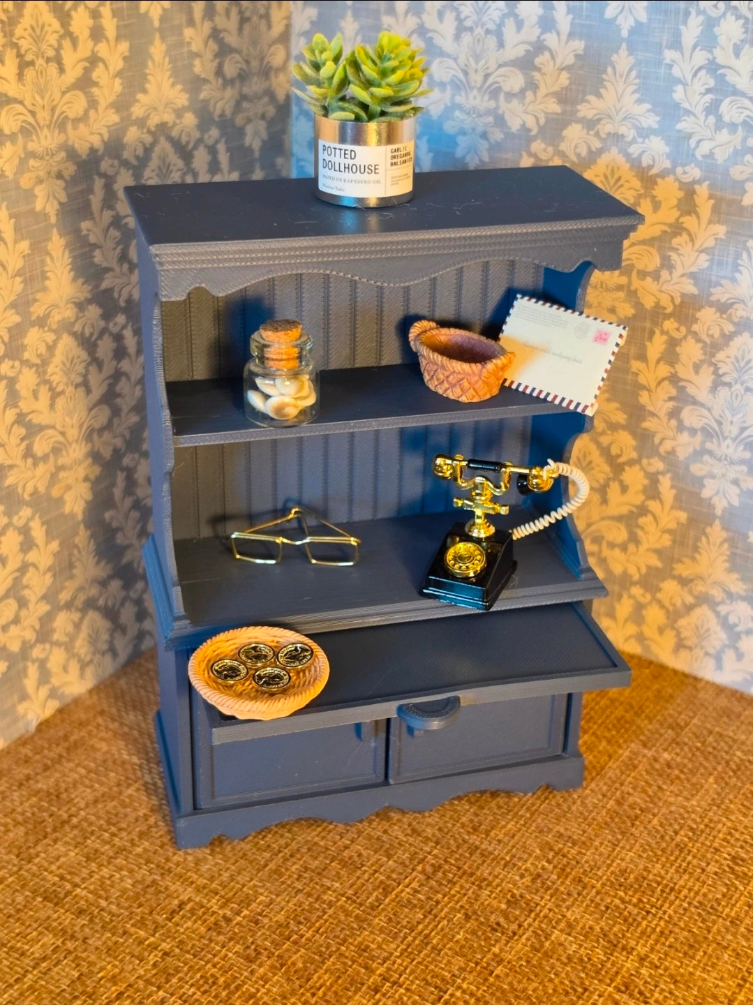 Buffet miniature bleu profond mis en scène avec de la vaisselle
