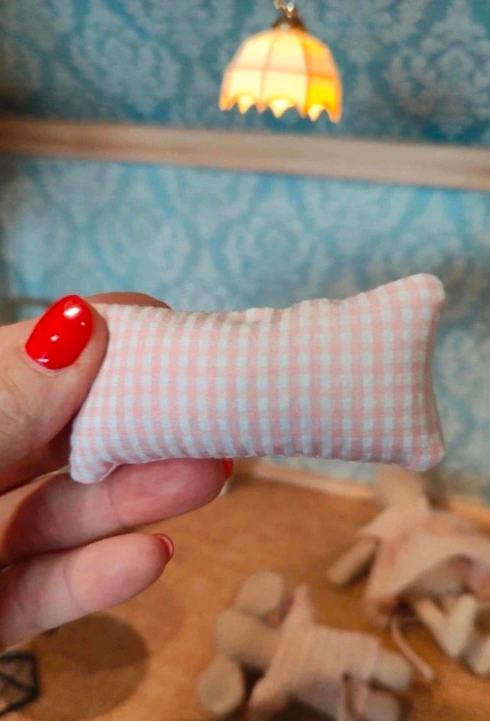 Coussin miniature vichy rose posé sur un fauteuil de maison de poupée