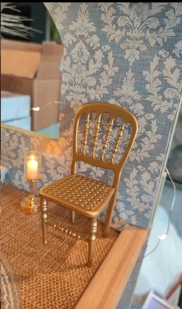 Détail de la finition dorée de la chaise miniature