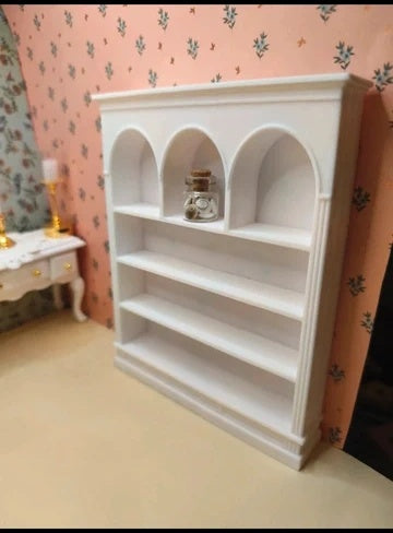 Étagère miniature à niches arrondies en situation dans une maison de poupée
