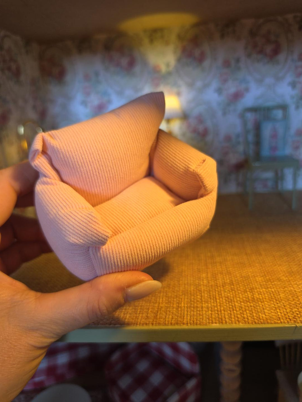 Fauteuil miniature en velours rose en situation dans un salon de maison de poupée