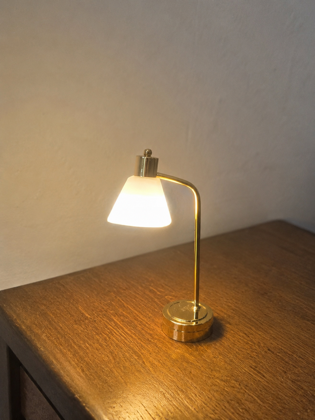 Lampe de bureau dorée miniature allumée