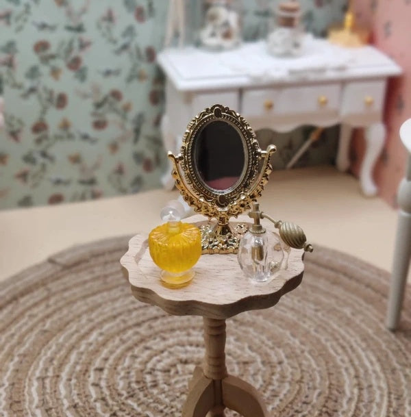 Détail de la monture dorée du miroir miniature sur pied