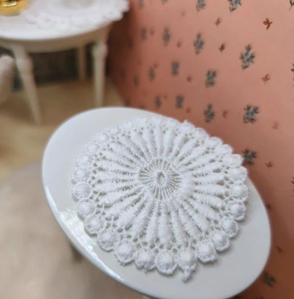 Napperon rond miniature posé sur une table de maison de souris