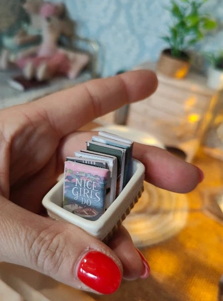Panier de livres miniature en situation dans un coin lecture de maison de poupée