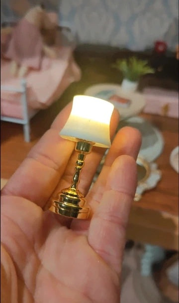 Petite lampe miniature allumée sur une table de chevet