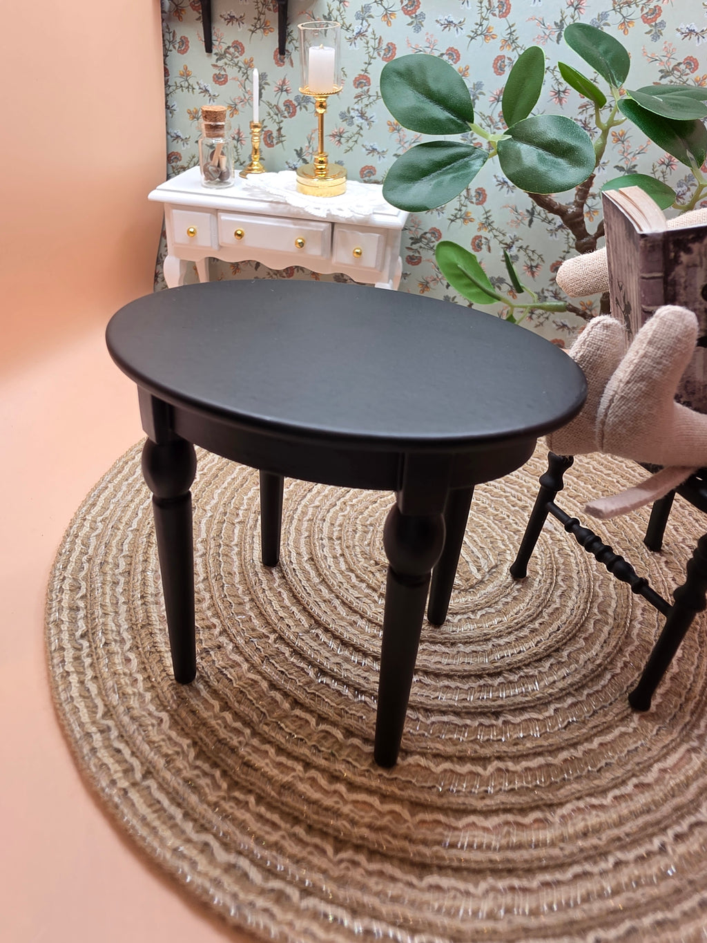 Table ovale miniature en métal noir dressée dans une maison de poupée