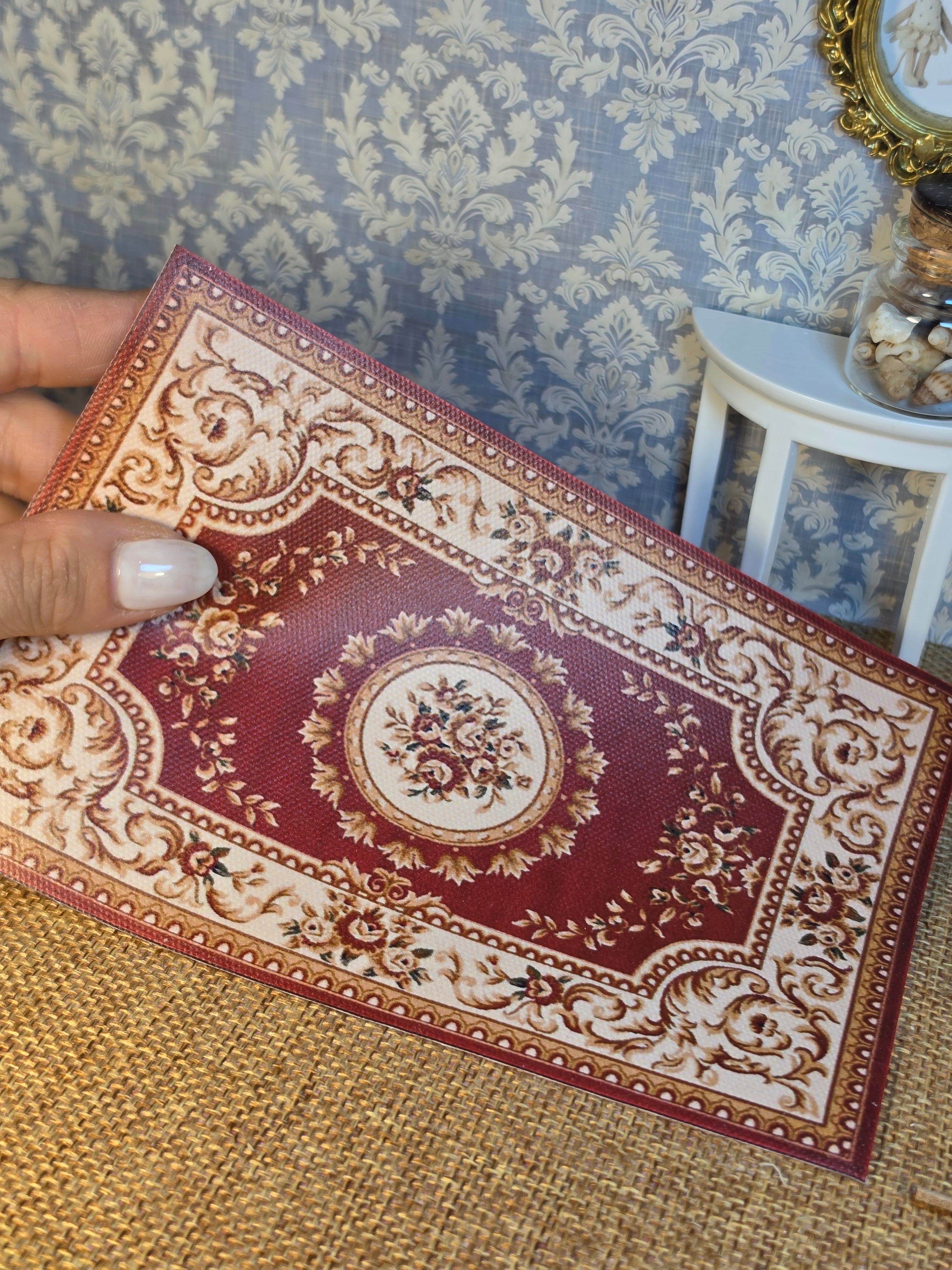 Détail des motifs bordeaux, crème et doré du tapis miniature
