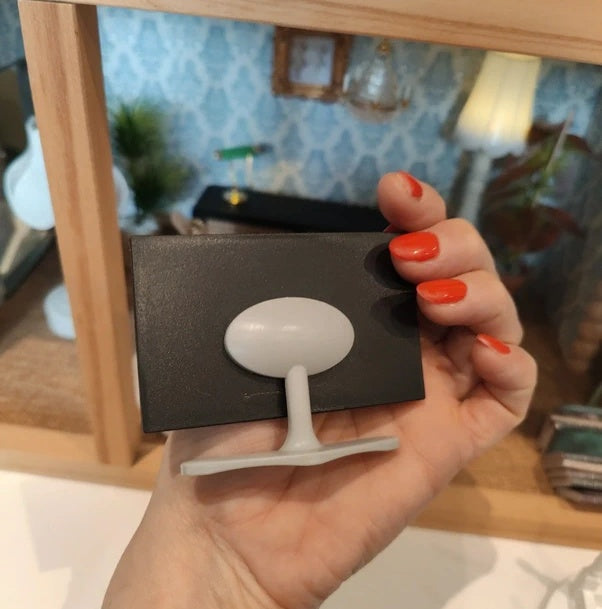 Télévision miniature en situation dans un salon de maison de poupée